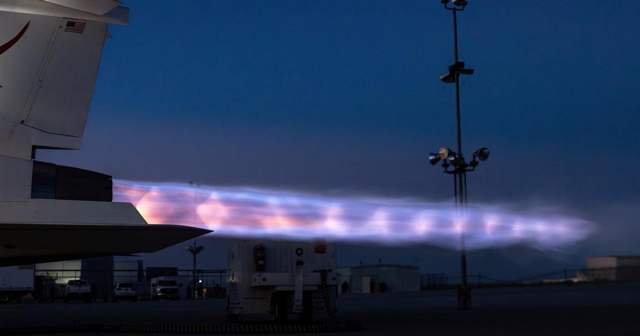 Shock diamonds glowing in the exhaust plume of an aircraft during a night engine run.